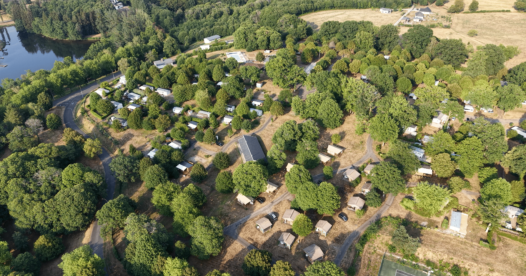 Vue aérienne du camping de Bournazel, avec ses hébergements et emplacements arborés près d’un plan d’eau.